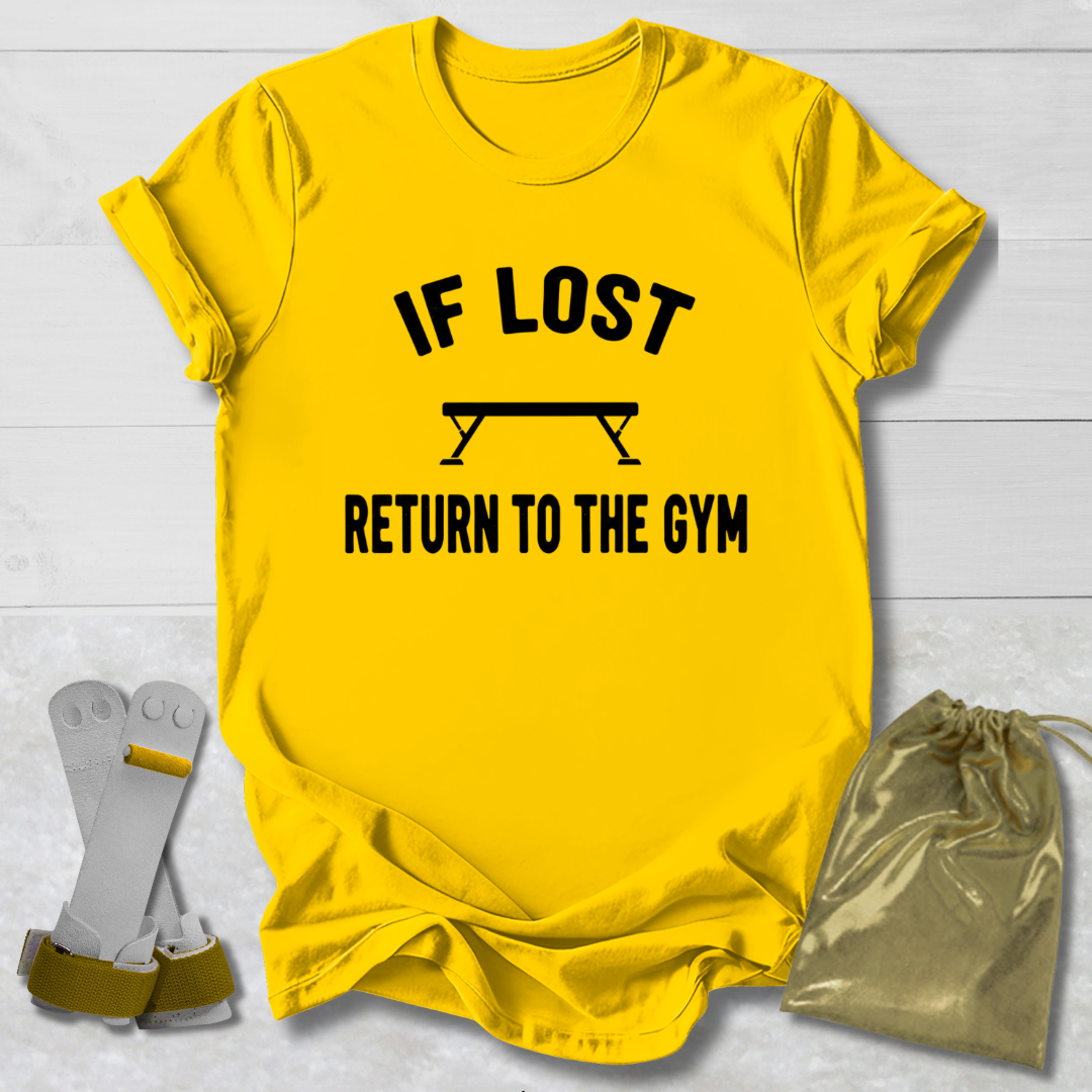 Yellow t-shirt with 'If lost, return to the gym' text on a light wooden surface.