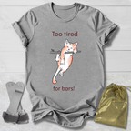 Gray t-shirt with a cat graphic and text, socks, and a drawstring bag on a wooden surface.