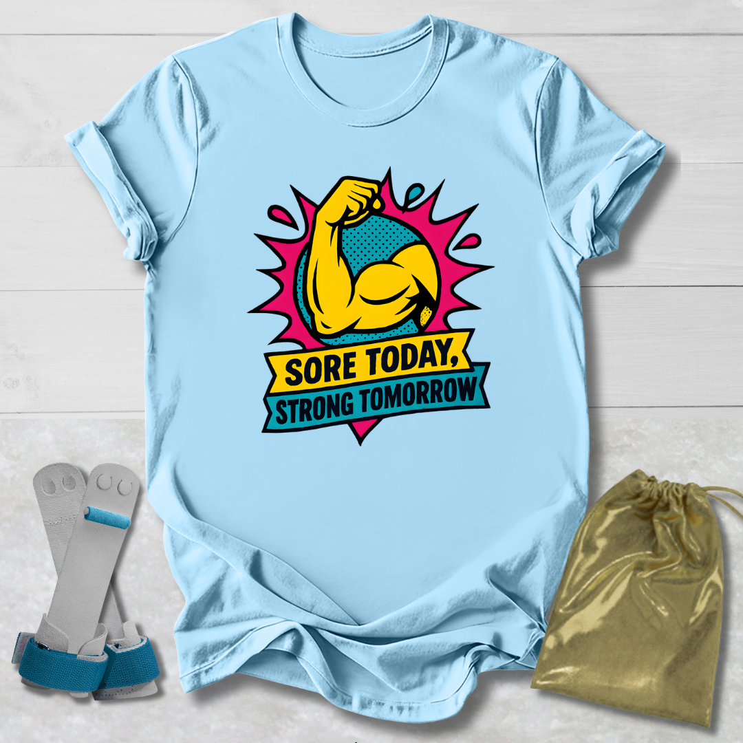 Light blue t-shirt with a graphic design and text, placed on a wooden surface with socks and a drawstring bag.