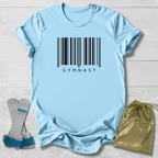 Light blue t-shirt with barcode and 'GYMNAST' text, paired with socks and a drawstring bag on a light wooden surface.