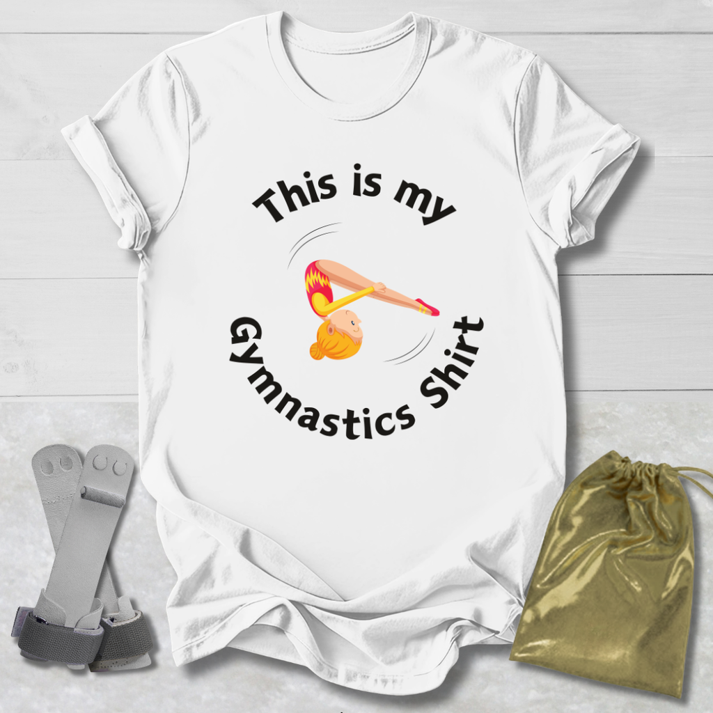 White t-shirt with gymnastics-themed design and accessories on a light wooden surface