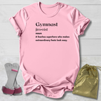 Pink t-shirt with 'Gymnast' definition text, socks, and drawstring bag on a light wooden surface