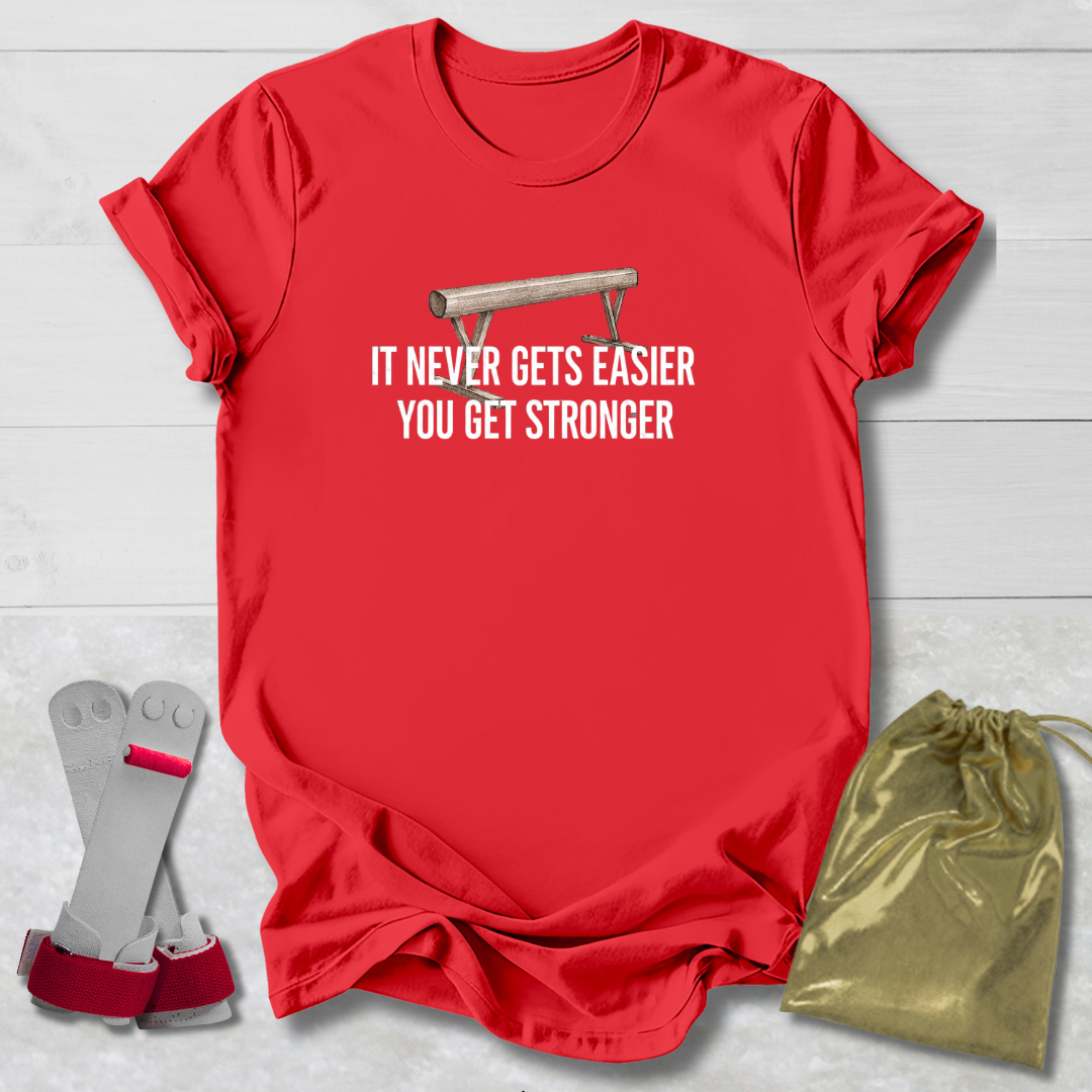 Red t-shirt with motivational gymnastics quote, socks, and drawstring bag on a light wooden surface