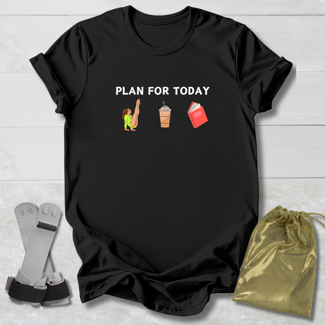 Black t-shirt with 'Gymnast Plan for Today' graphic on a wooden surface with socks and a drawstring bag.