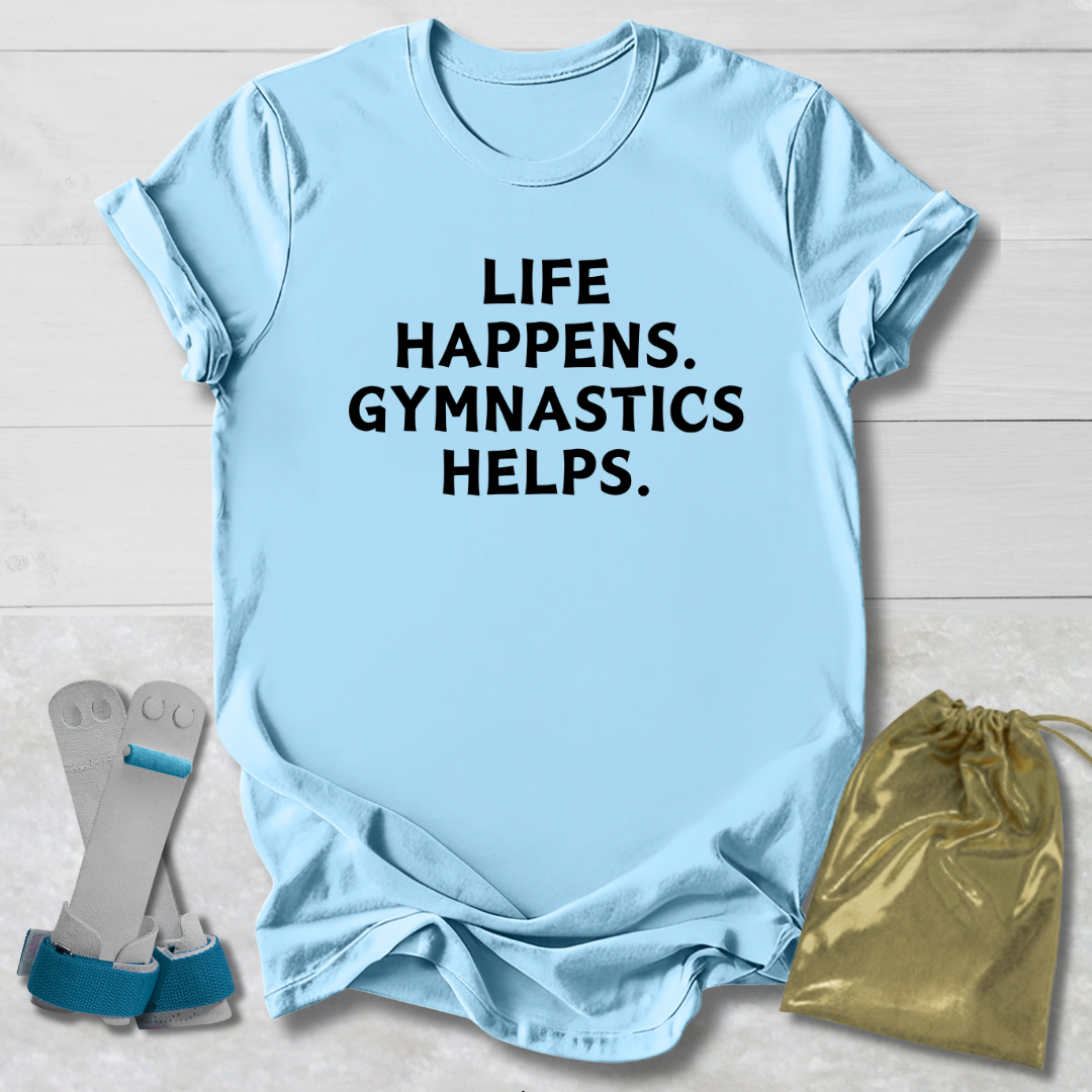 Light blue t-shirt with 'Life happens. Gymnastics helps.' text, socks, and drawstring bag on a light wooden surface.