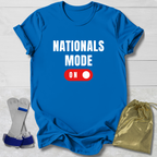 Blue t-shirt with 'NATIONALS MODE ON' text, socks, and drawstring bag on a light wooden surface