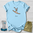 Light blue t-shirt with a graphic of a gymnast and the word 'Floor', displayed with socks and a drawstring bag on a light wooden surface.