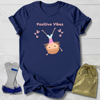 Navy blue t-shirt with 'Positive Vibes' graphic on a light wooden surface with socks and a drawstring bag.