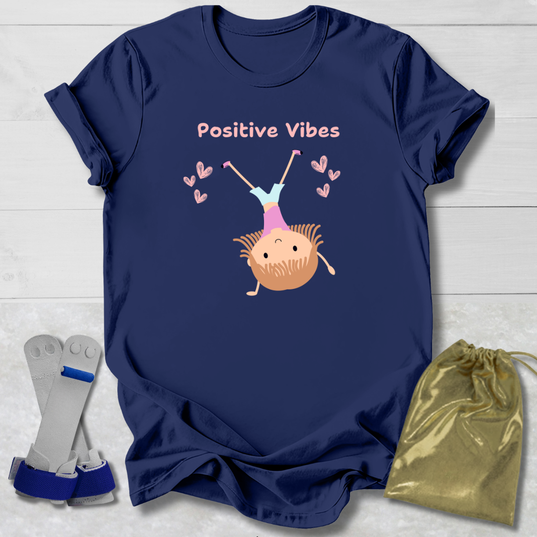 Navy blue t-shirt with 'Positive Vibes' graphic on a light wooden surface with socks and a drawstring bag.