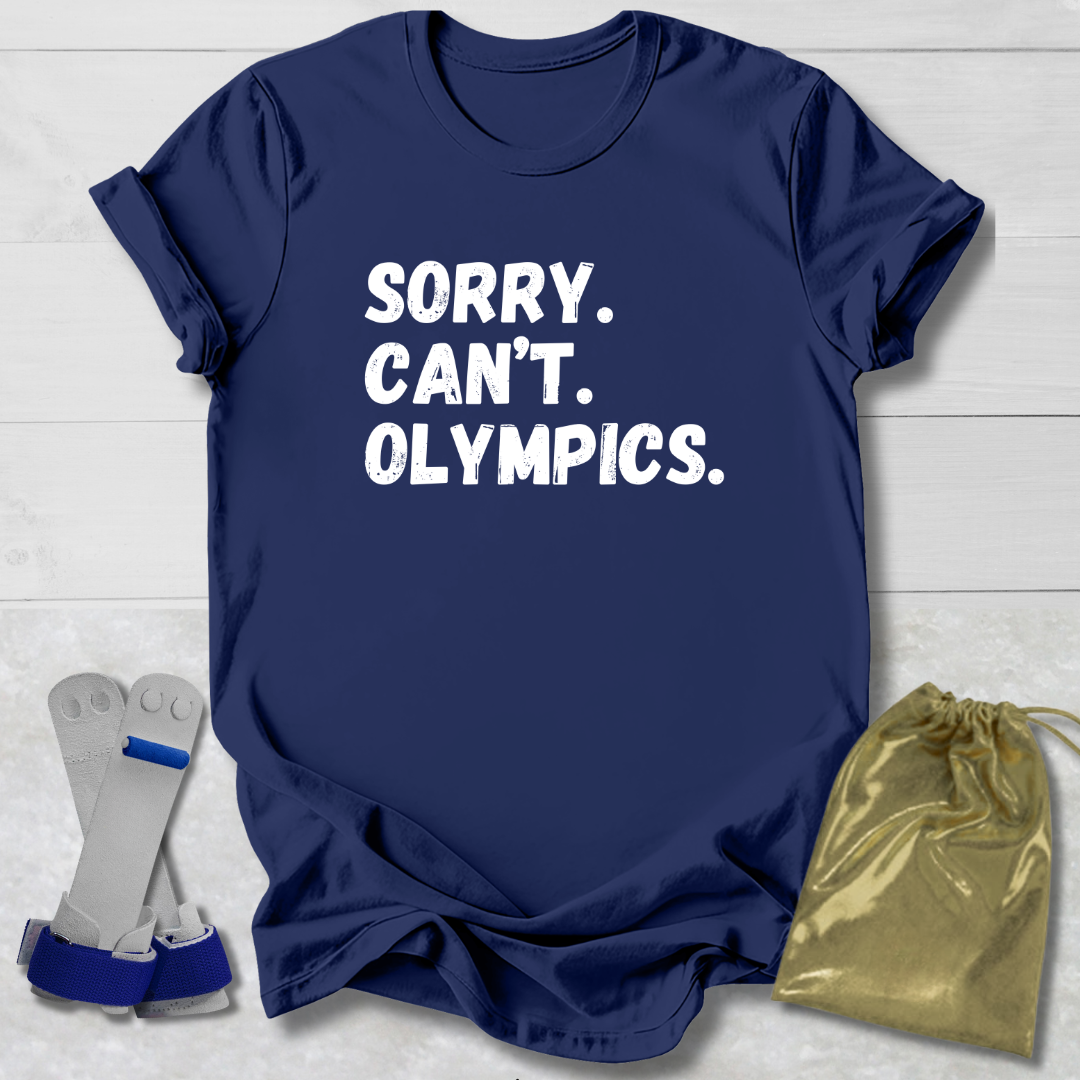 Navy blue t-shirt with 'Sorry. Can't. Olympics.' text, socks, and drawstring bag on a light wooden surface.