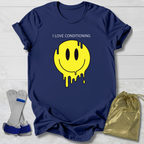 Navy blue t-shirt with yellow smiley face graphic and text, socks, and drawstring bag on a light wooden surface.