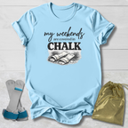 Light blue t-shirt with 'my weekends are covered in CHALK' text and graphic, displayed with socks and a drawstring bag on a light wooden surface.
