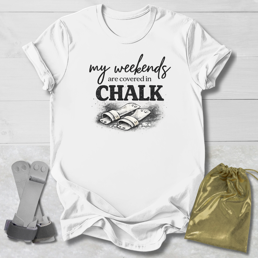 White t-shirt with 'my weekends are covered in CHALK' text and graphic on a light wooden surface.