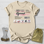 Beige t-shirt with gymnast-themed design on a light wooden surface, accompanied by socks and a drawstring bag.