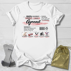 White t-shirt with gymnast-themed design on a light wooden surface, accompanied by gray socks and a gold drawstring bag.