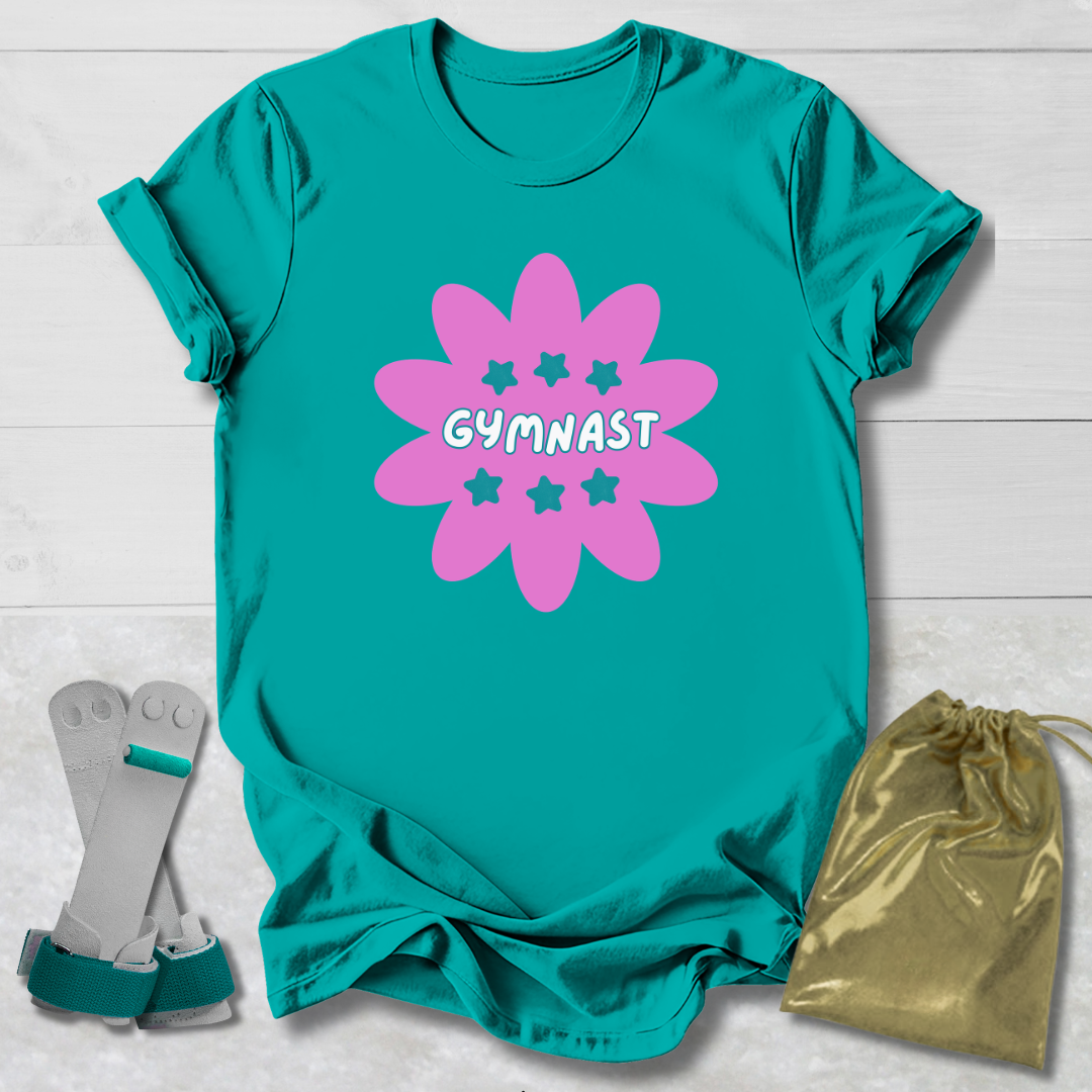 Teal t-shirt with pink gymnast design, socks, and drawstring bag on a light wooden surface