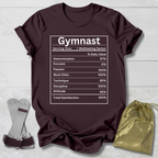 Maroon t-shirt with 'Gymnast' graphic on a wooden surface with socks and a drawstring bag.
