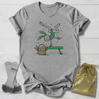 Gray t-shirt with a cartoon design of a rabbit on a bench with an Easter basket, socks, and a drawstring bag on a light wooden surface.