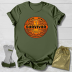 Green t-shirt with 'Survivor' Gymnast Edition graphic design on a wooden surface with socks and a drawstring bag.