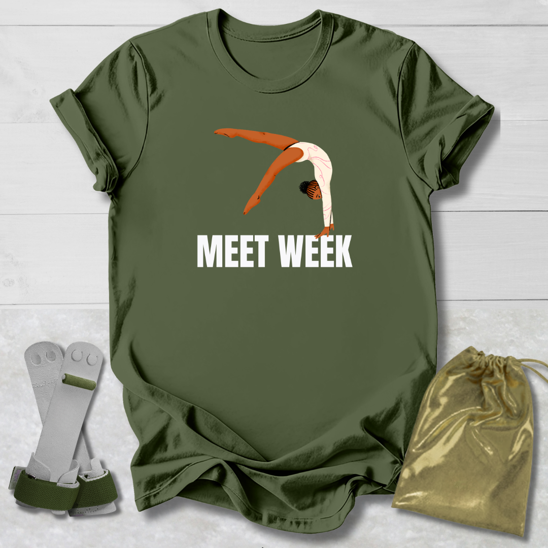Green t-shirt with diving graphic and 'MEET WEEK' text, socks, and drawstring bag on a light wooden surface.