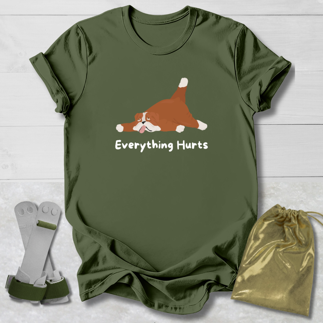 Green t-shirt with a cartoon dog and 'Everything Hurts' text, socks, and drawstring bag on a light wooden surface.