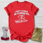 Red t-shirt with white I don't always do gymnastics . . . wait, yes I do text and graphics on a light wooden surface, accompanied by gray socks and a gold drawstring bag.