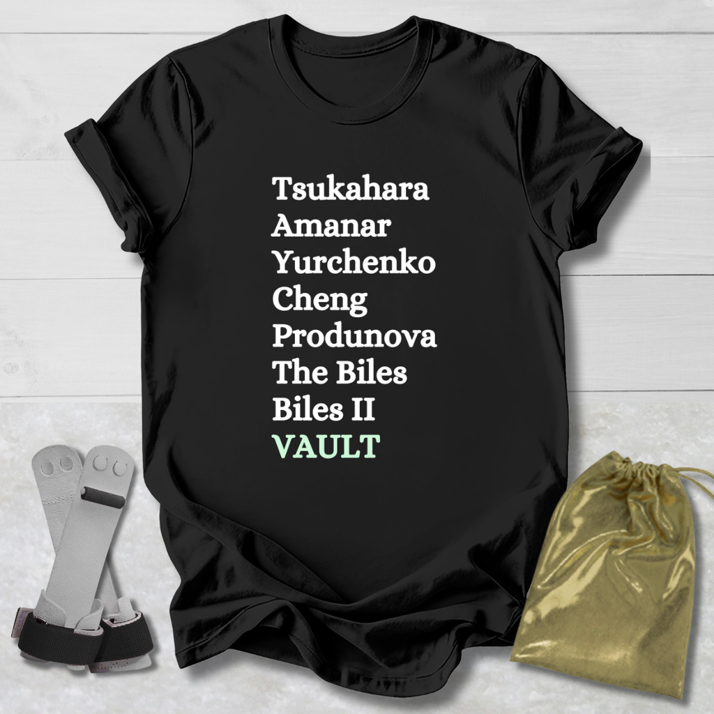 Black t-shirt with  gymnast vault skills text on a wooden surface with socks and a drawstring bag.
