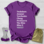 Purple t-shirt with gymnast vault skills text, socks, and drawstring bag on a light wooden surface