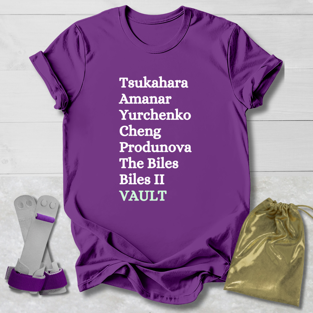 Purple t-shirt with gymnast vault skills text, socks, and drawstring bag on a light wooden surface