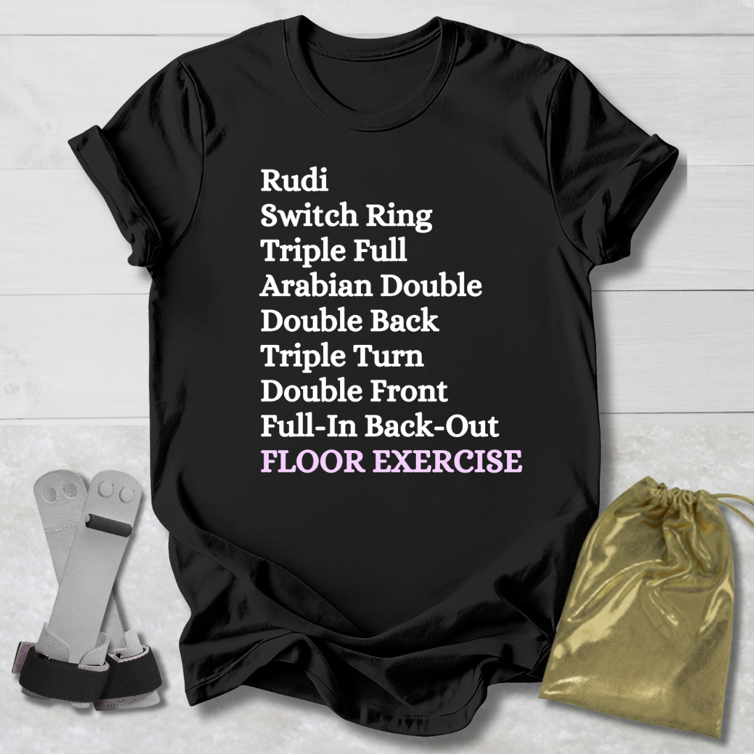 Black t-shirt with gymnast floor exercise skills text on a wooden surface with socks and a drawstring bag.