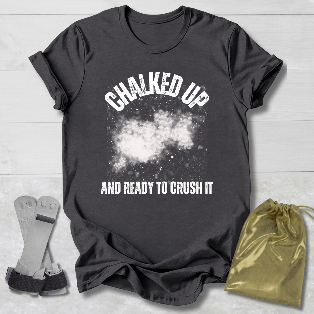 Gray t-shirt with 'Chalked Up and Ready to Crush It' text, socks, and drawstring bag on a light wooden surface.