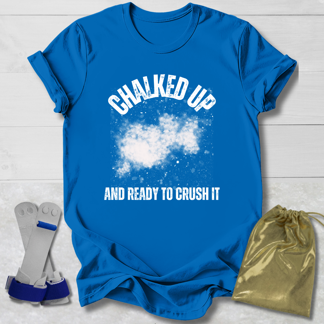 Blue t-shirt with 'Chalked Up and Ready to Crush It' text, socks, and drawstring bag on a light wooden surface.