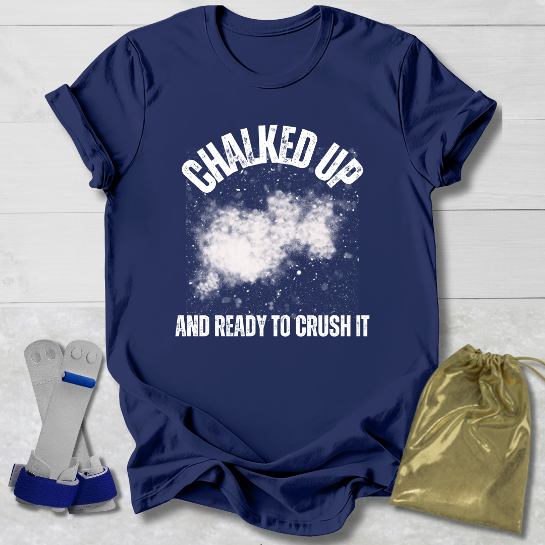 Navy blue t-shirt with 'Chalked Up and Ready to Crush It' text, socks, and drawstring bag on a light wooden surface.