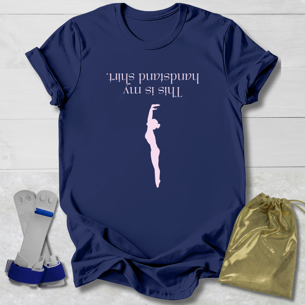 Navy blue t-shirt with a graphic and  this is my handstand shirt text, placed on a light wooden surface with socks and a drawstring bag.