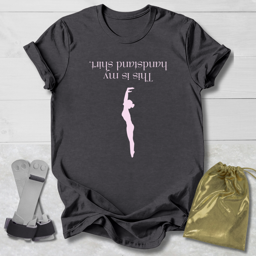 Dark gray t-shirt with a graphic and  this is my handstand shirt text, socks, and a drawstring bag on a light wooden surface.