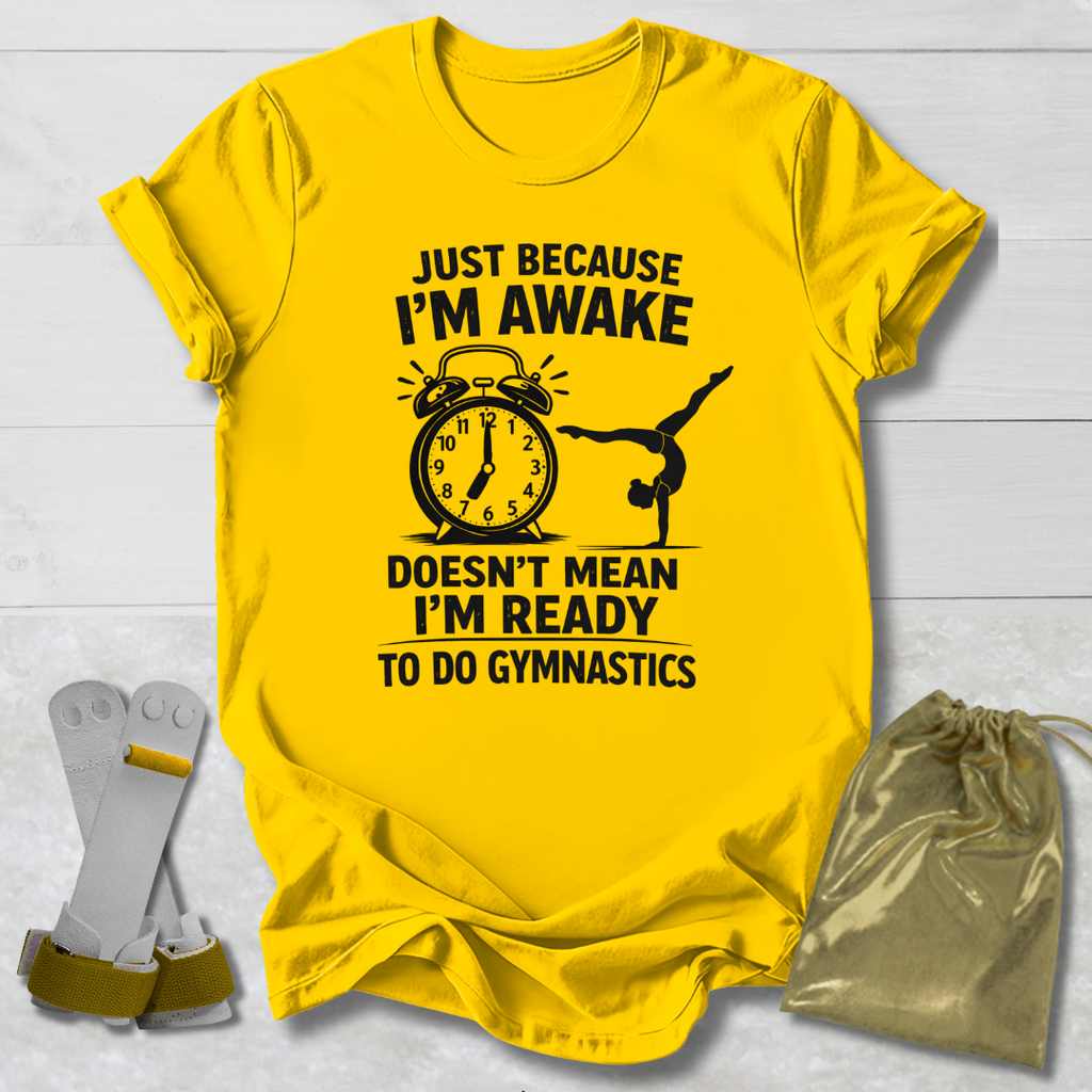 Yellow t-shirt with a humorous gymnast graphic and text on a light wooden surface.