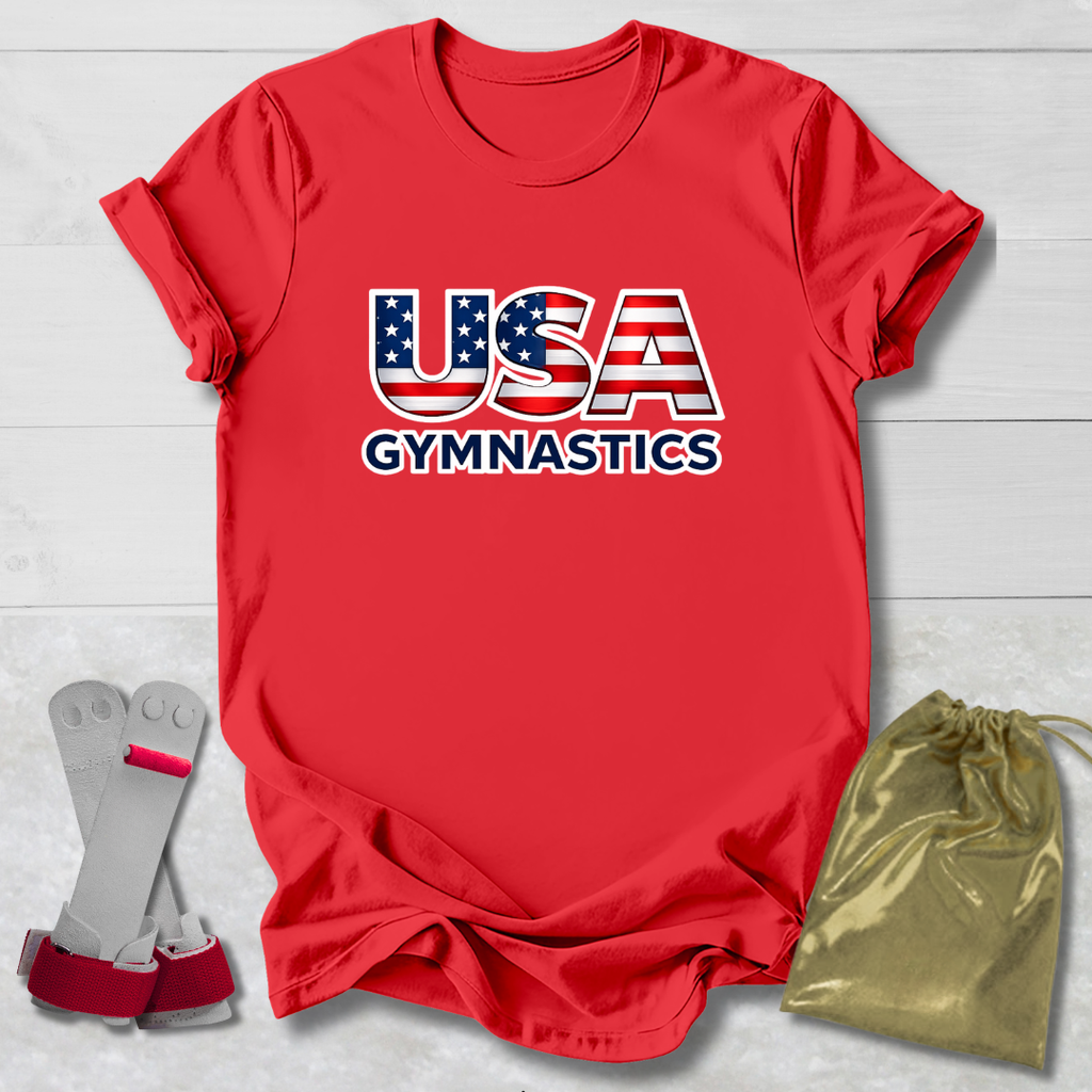 Red t-shirt with 'USA Gymnastics' design, socks, and drawstring bag on a light wooden surface