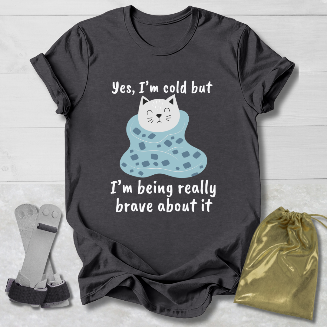 Dark gray t-shirt with a cat Yes I'm cold graphic and text on a light wooden surface.