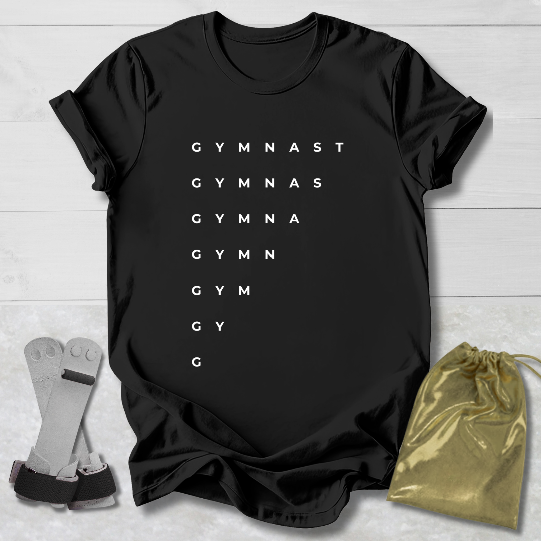 Black t-shirt with 'GYMNAST' text, socks, and drawstring bag on a light wooden surface