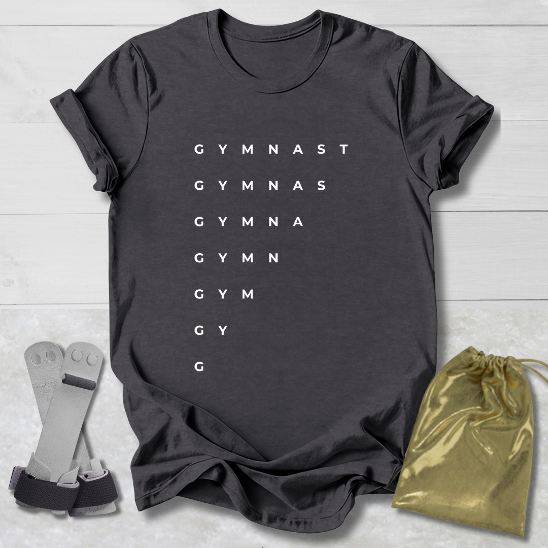 Dark gray t-shirt with 'GYMNAST' text, socks, and drawstring bag on a light wooden surface