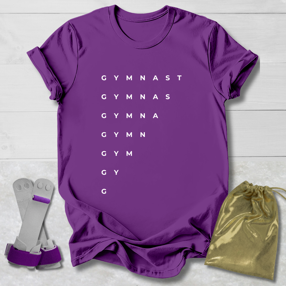 Purple t-shirt with 'GYMNAST' text, socks, and drawstring bag on a light wooden surface