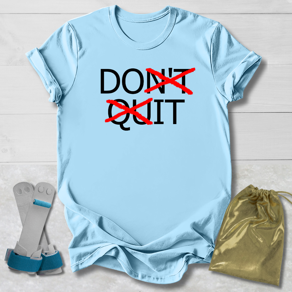 Light blue t-shirt with 'DON'T QUIT' text, socks, and drawstring bag on a wooden surface