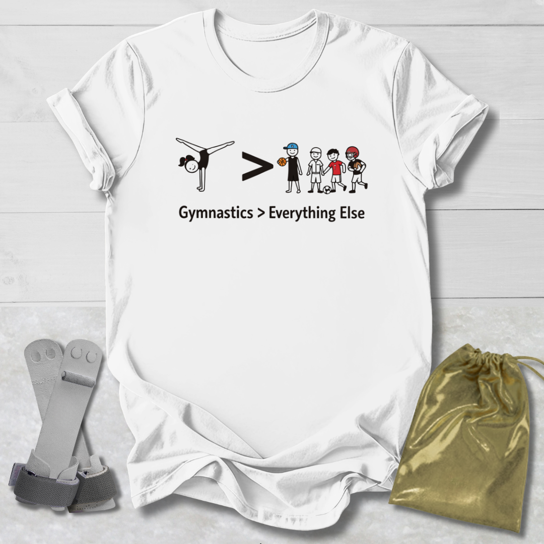White t-shirt with gymnastics-themed graphic and text on a light wooden surface, accompanied by socks and a drawstring bag.