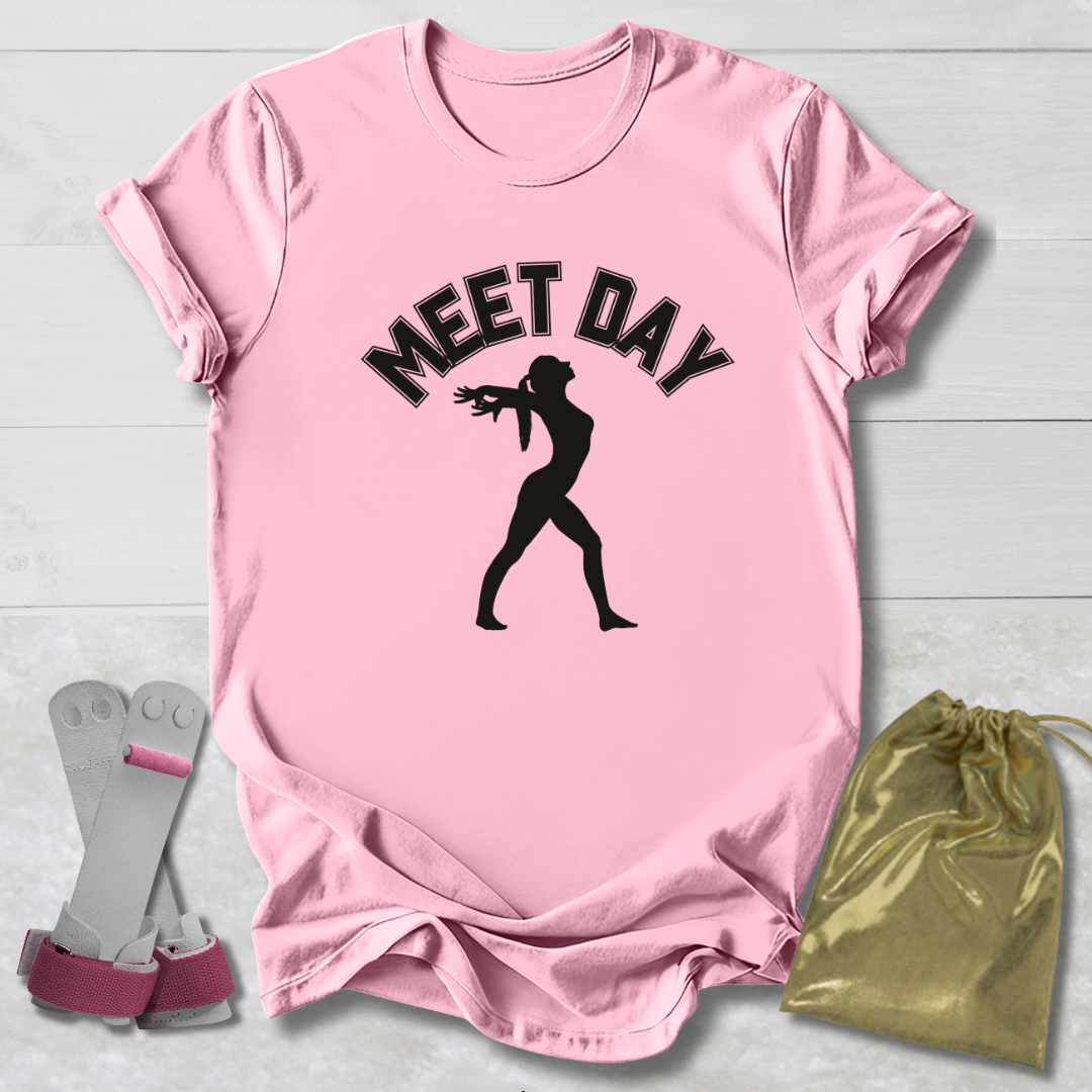 Pink t-shirt with 'MEET DAY' text and silhouette, socks, and drawstring bag on a light wooden surface