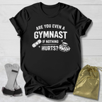 Black t-shirt with humorous gymnast text, socks, and drawstring bag on a light wooden surface