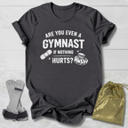 Gray t-shirt with humorous gymnast graphic and text on a light wooden surface.