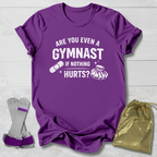 Purple t-shirt with humorous gymnast text, socks, and drawstring bag on a light wooden surface