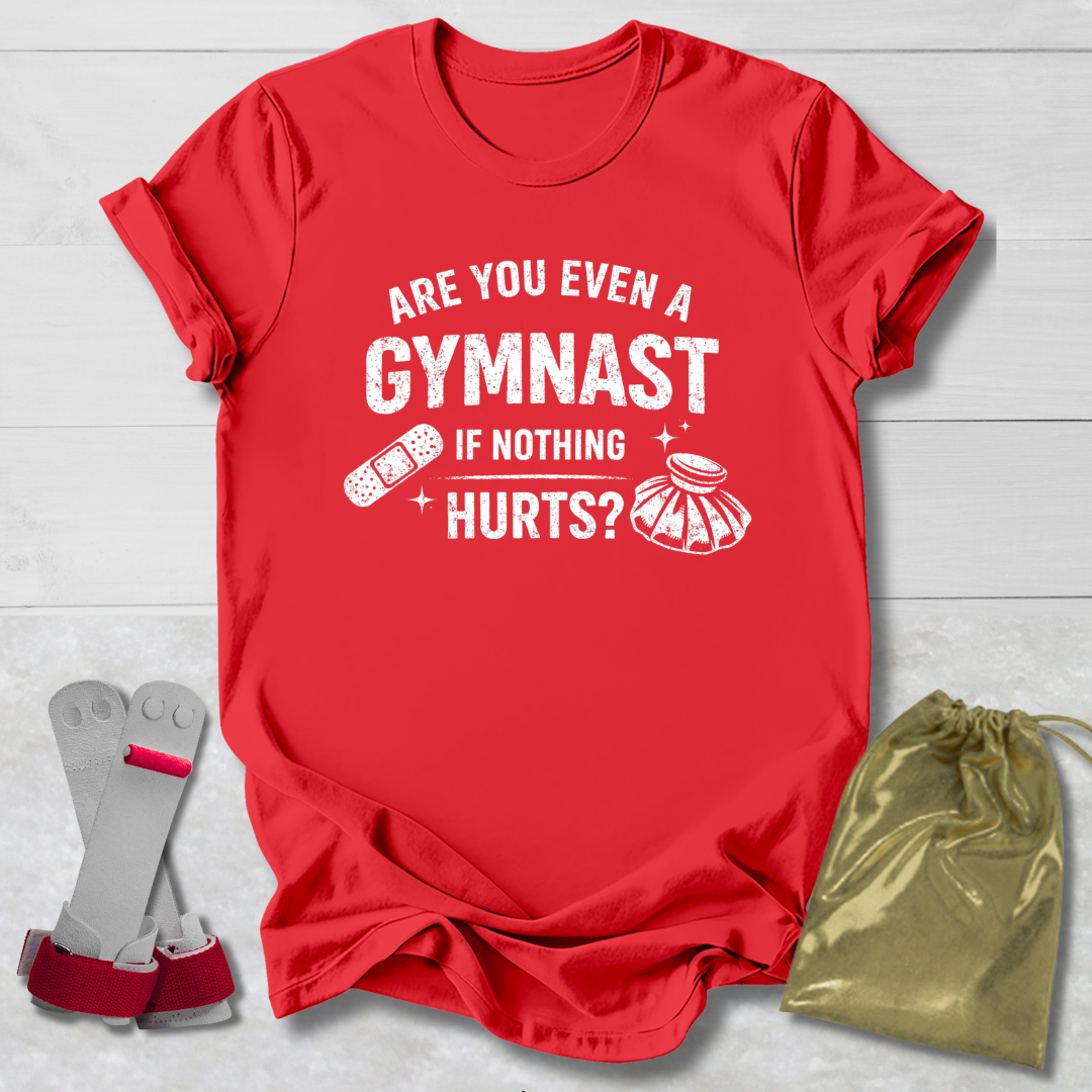 Red t-shirt with humorous gymnast text, socks, and drawstring bag on a light wooden surface