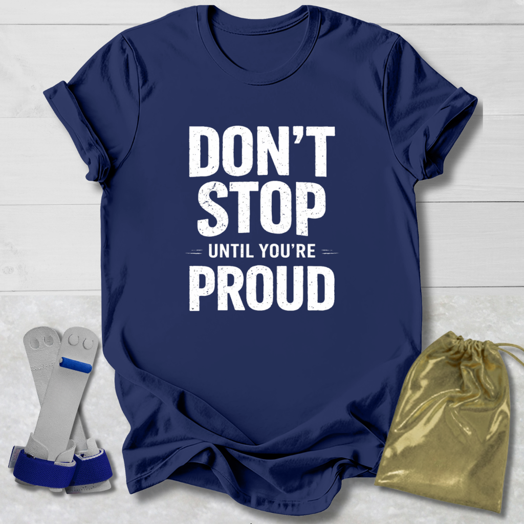 Navy blue t-shirt with 'Don't Stop Until You're Proud' text, socks, and drawstring bag on a light wooden surface.