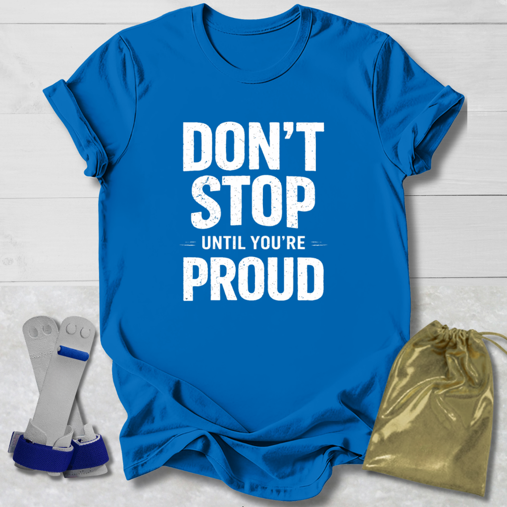 Blue t-shirt with 'Don't Stop Until You're Proud' text, socks, and drawstring bag on a light wooden surface.